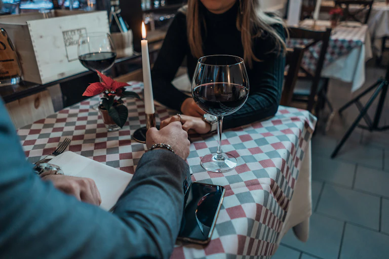 Deux personnes se tiennent la main sur une petite table dans un restaurant.