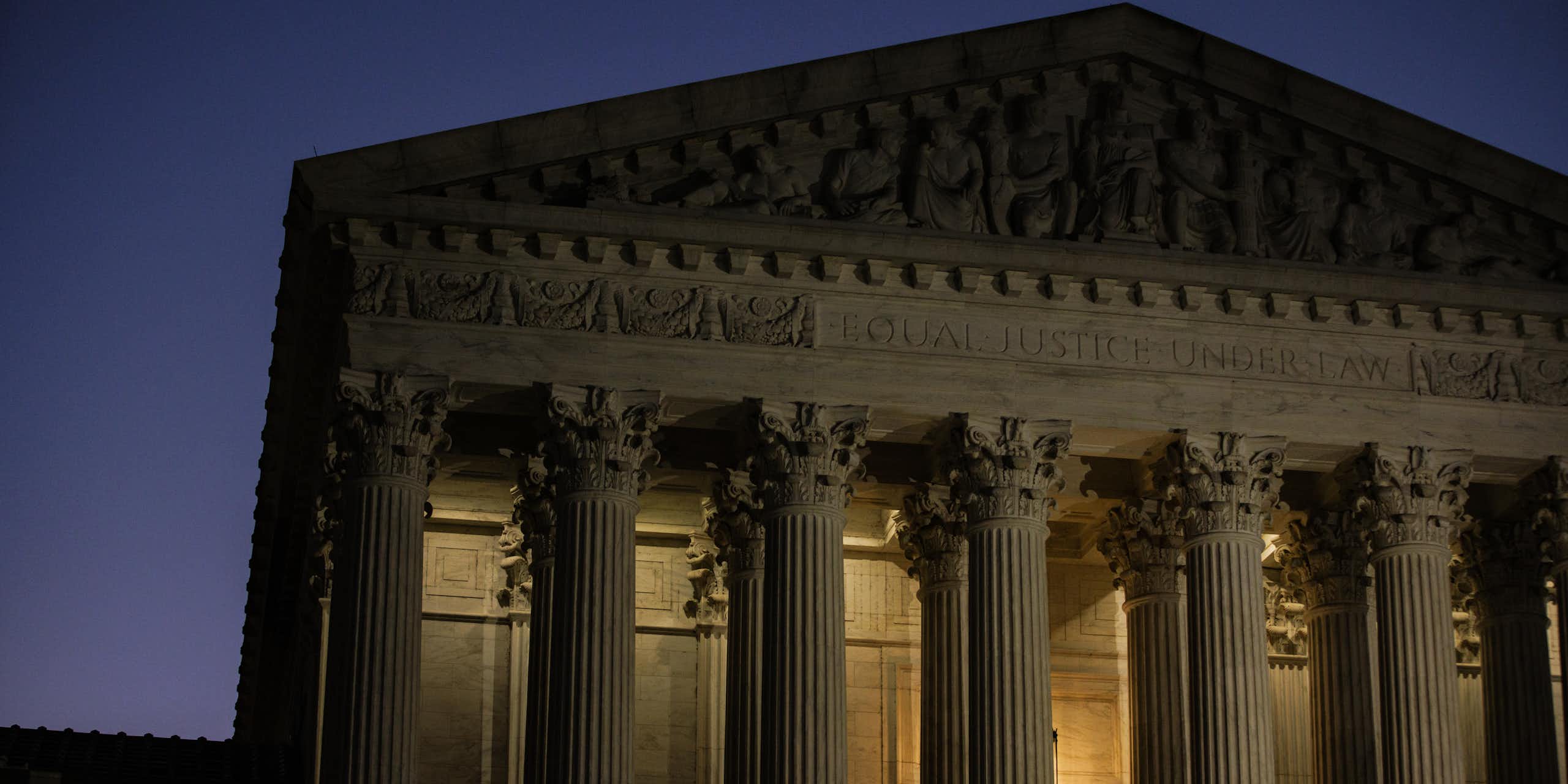 A large white, columned building at dawn.