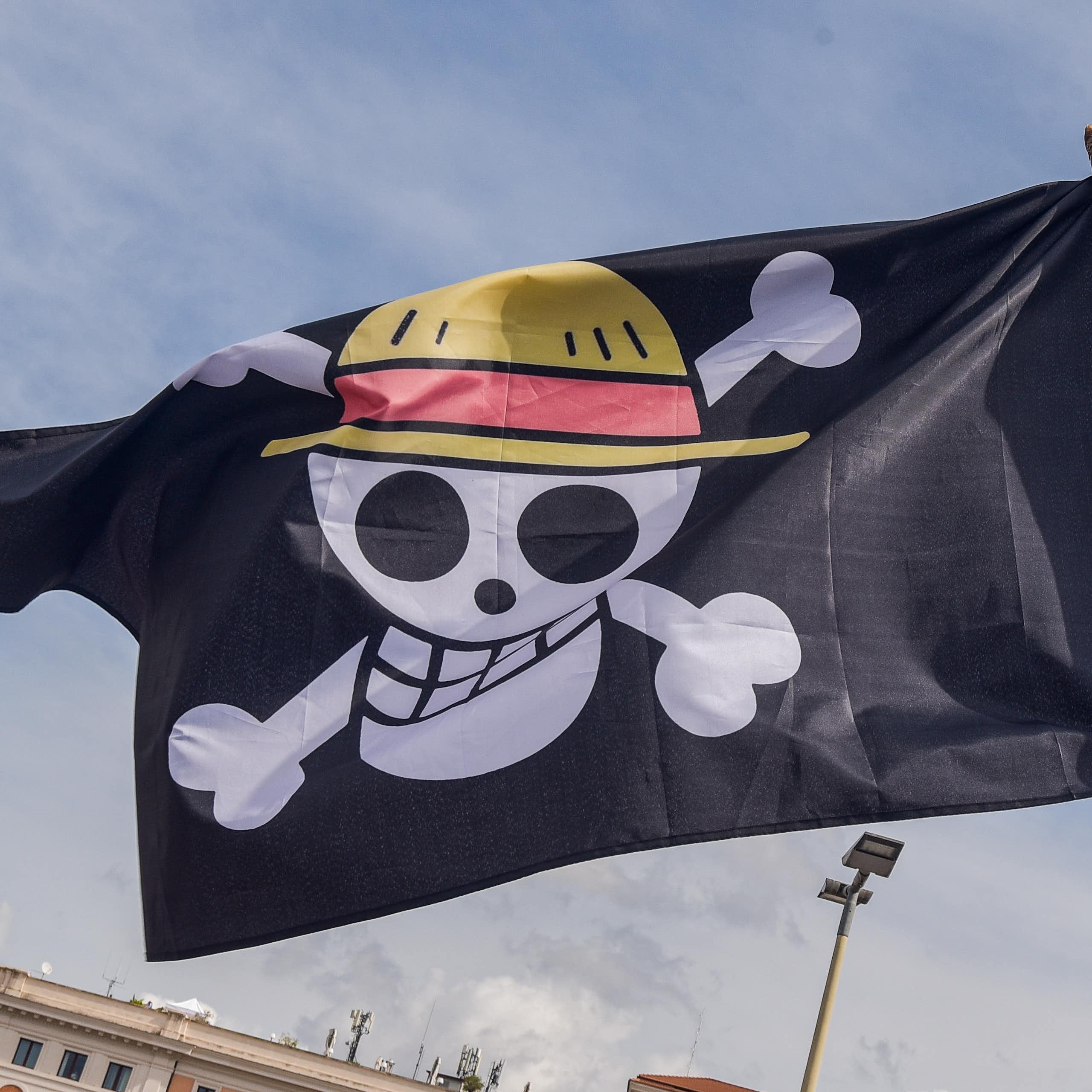 A grinning skull and crossbones is seen on a black flag.
