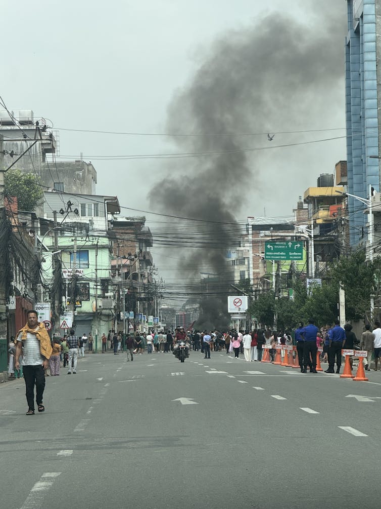 A plume of smoke rising from a street in Kathmandu.