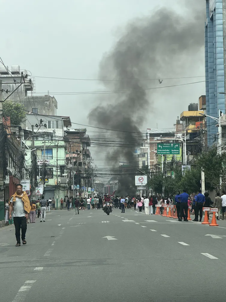 A plume of smoke rising from a street in Kathmandu.