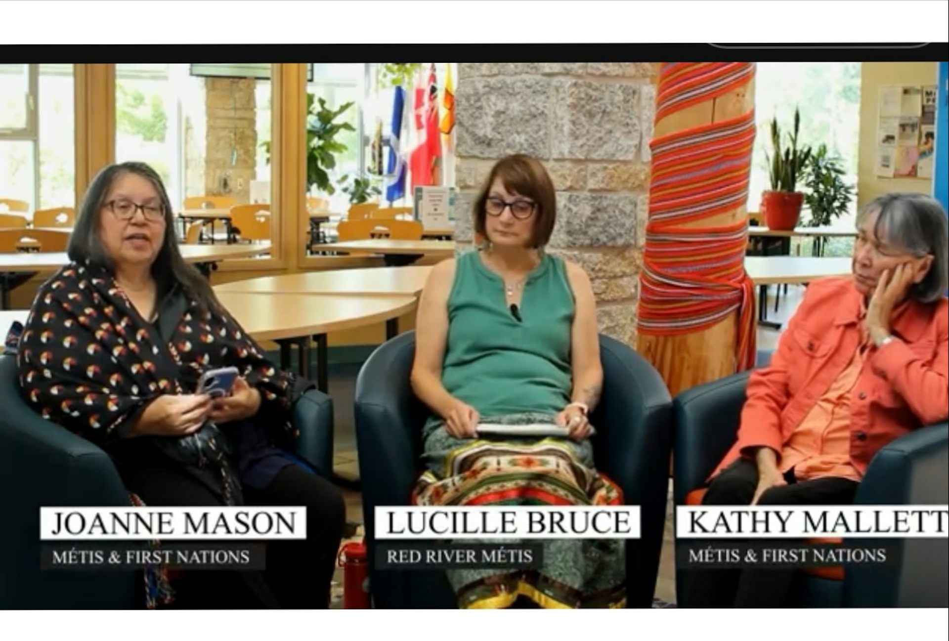 Tres mujeres se sientan una frente a la otra conversando.