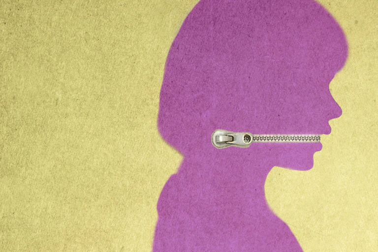A purple silhouette of a person's side profile is seen with a zipper closed in the mouth area.
