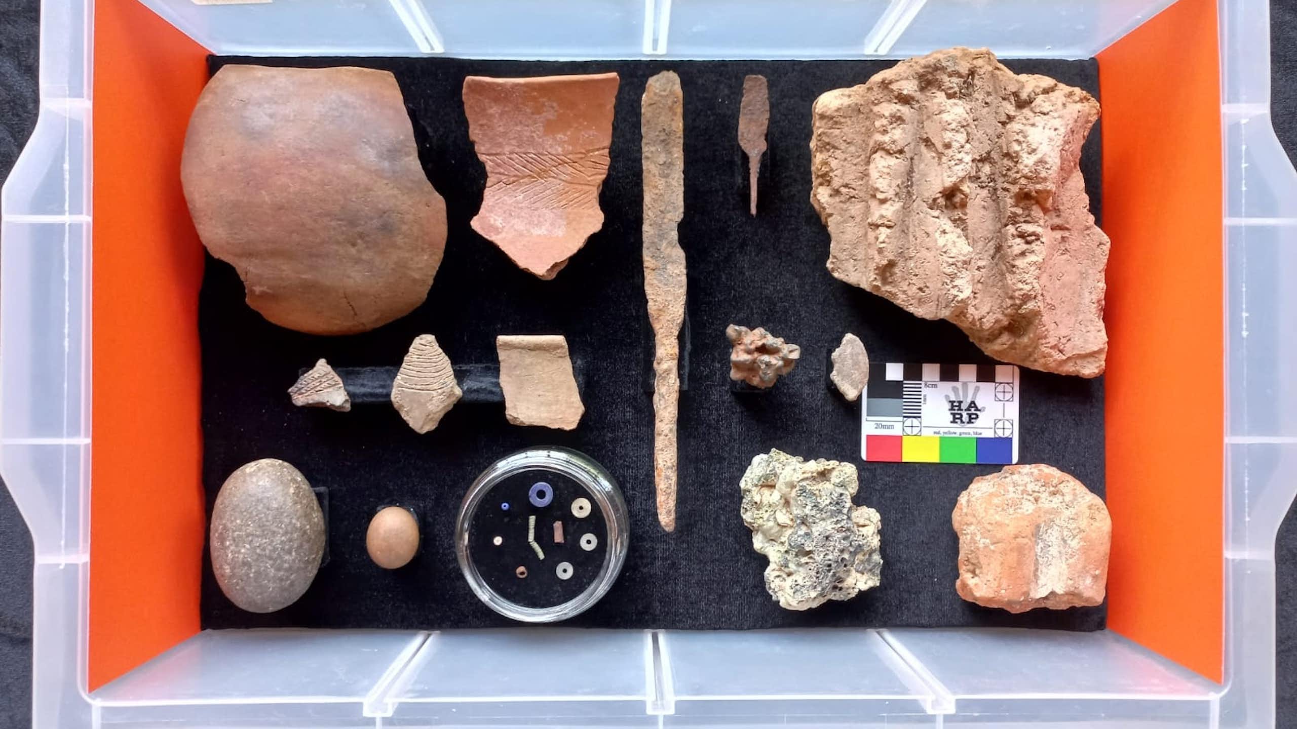 Pottery sherds, stone tools, beads, fragments of iron in a plastic box