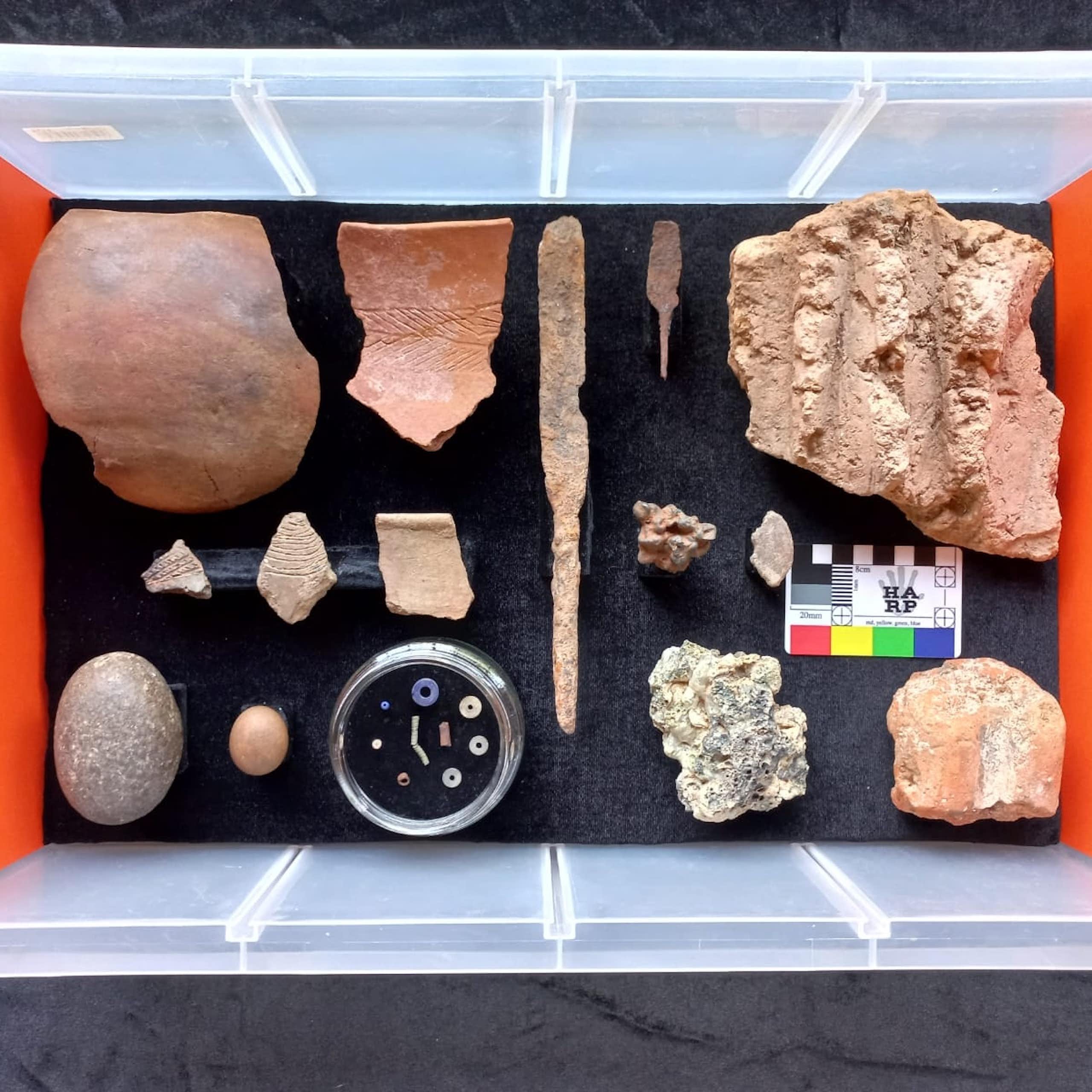 Pottery sherds, stone tools, beads, fragments of iron in a plastic box
