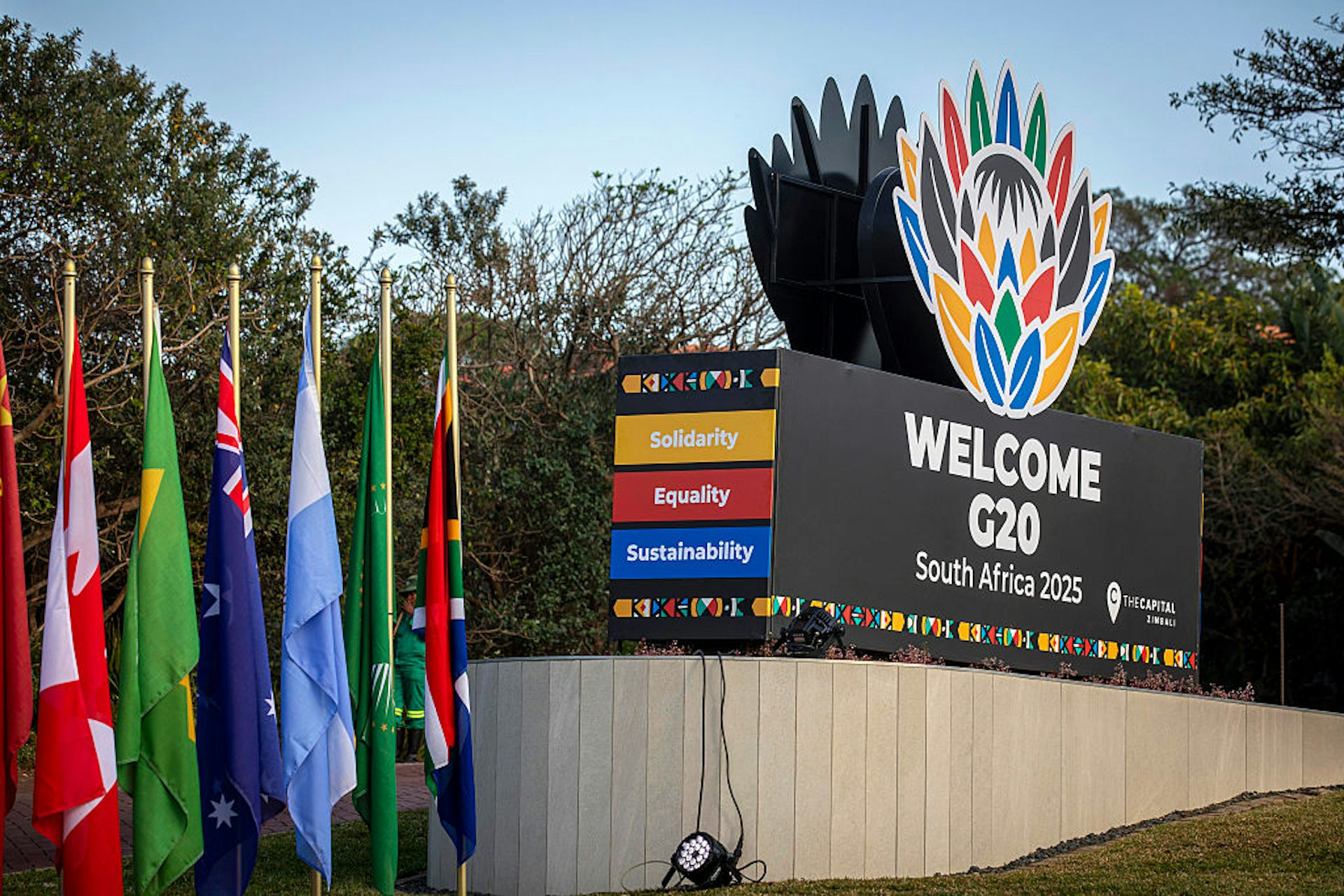 Signage showing different coloured flags and a large block written 'Welcome G20 South Africa'