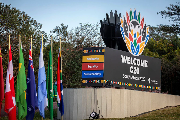 Signage showing different coloured flags and a large block written 'Welcome G20 South Africa'