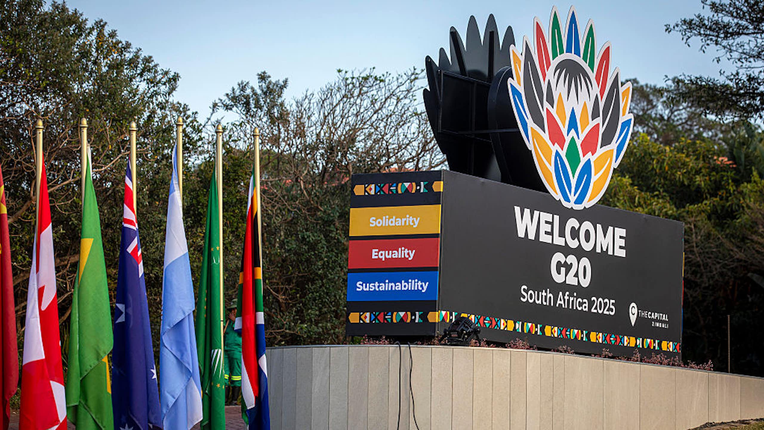 Signage showing different coloured flags and a large block written 'Welcome G20 South Africa'