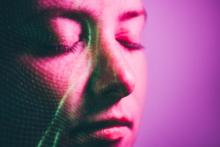 A woman's face being scanned with a mesh of light
