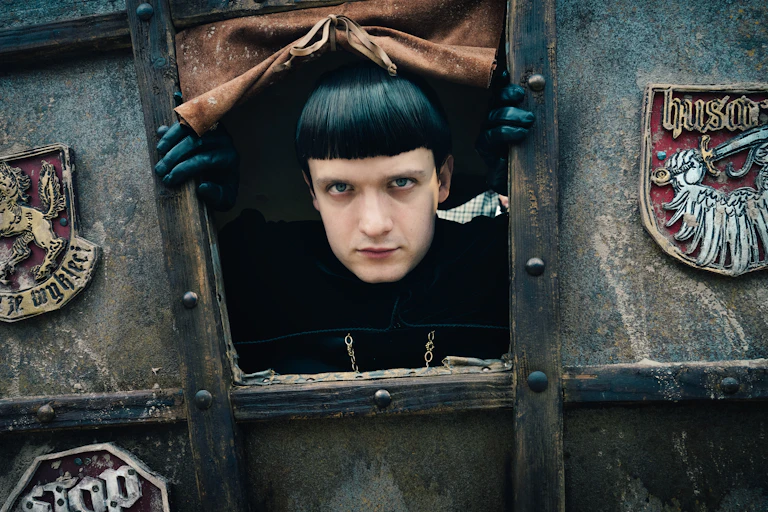 A man stares out from a carriage.