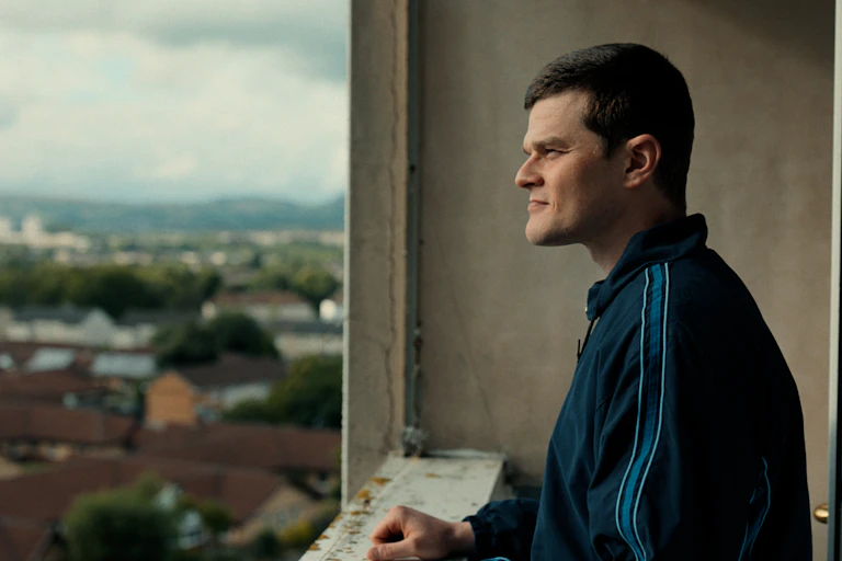 A man stood on a balcony overlooking the city of London