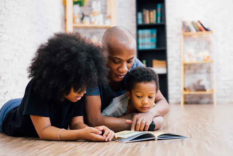 Children and father reading together