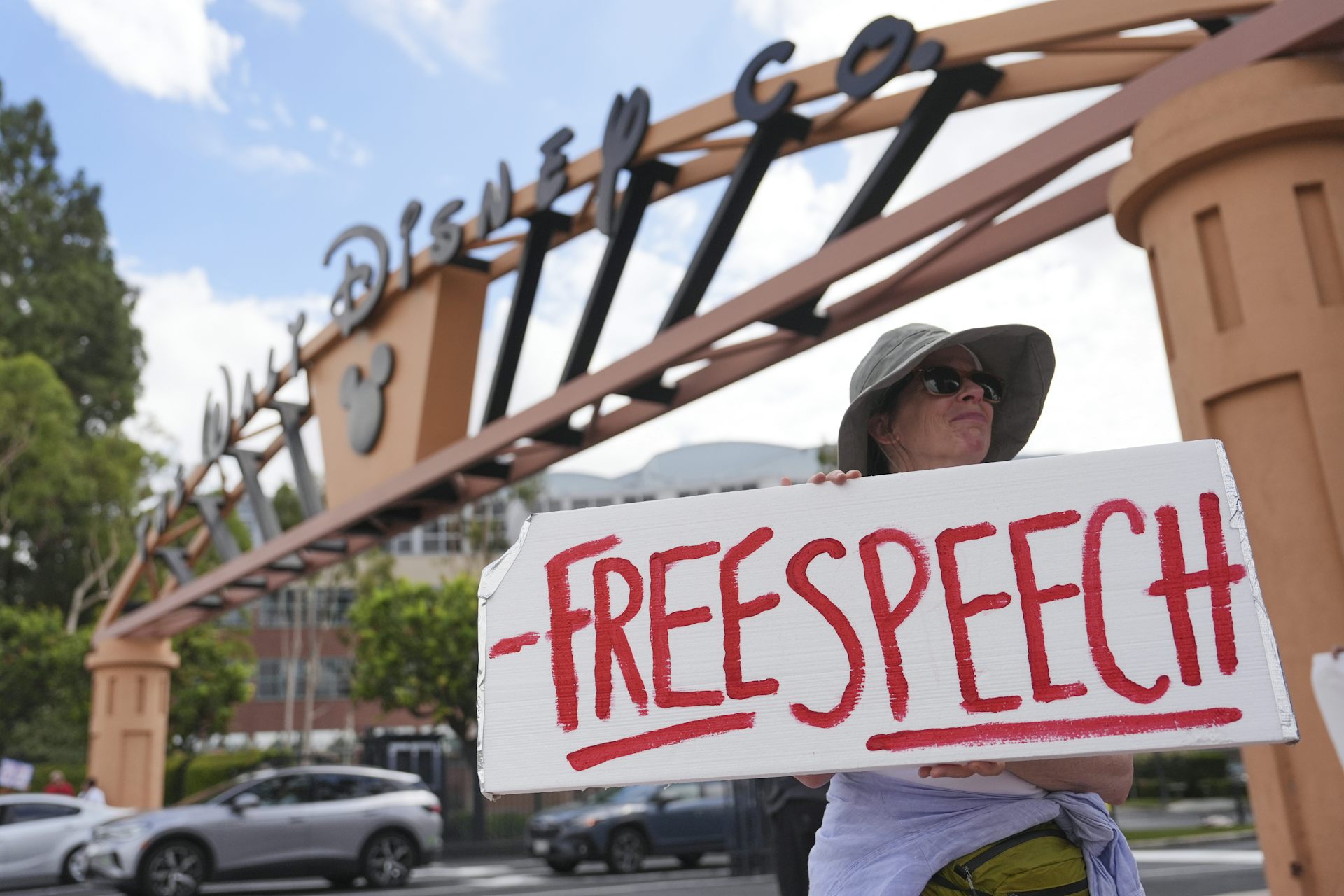 A demonstrator holds a sign that reads Free Speech.