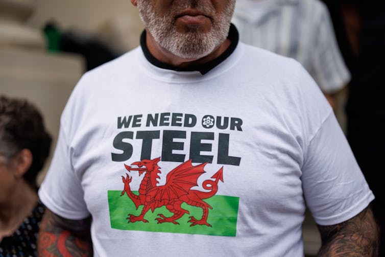 man wearing 'we need our steel' t shirt with a welsh dragon