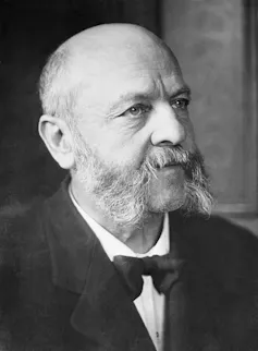 Black-and-white portrait of bald man with mutton chops.
