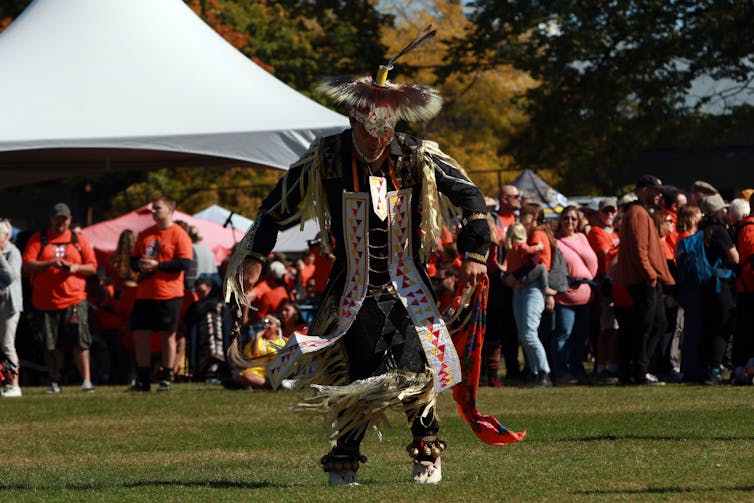 Hombre vestido con ropa autóctona tradicional y baile durante el hacinamiento.