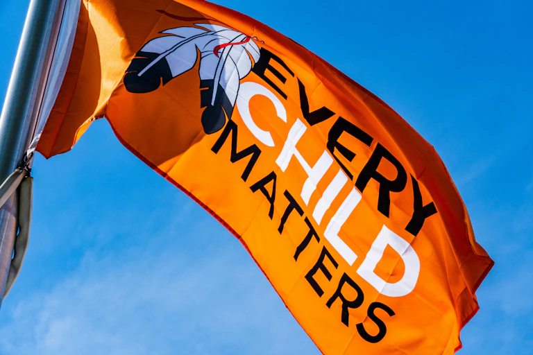 A flag that reads "Every Child Matters" is waving in the air.