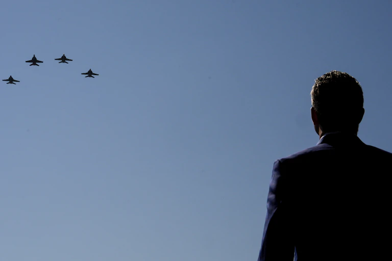 A man's silhouette watching four airplanes flying in formation.