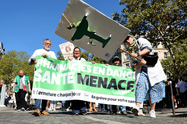 Des pharmaciens manifestent avec une banderole et des pancartes à Paris, le 18 septembre 2025.