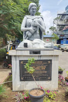 stone statue of mother feeding baby outside hospital