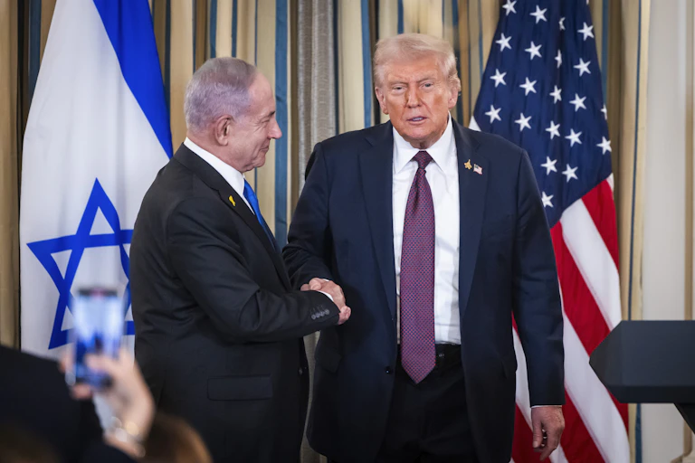 Donald Trump shakes hands with Benjamin Netanyahu.