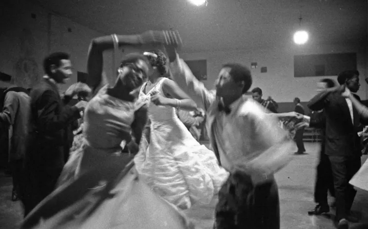 A black and white photo of couples dancing in a blur.
