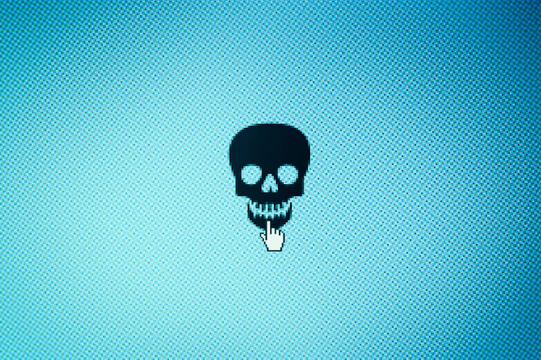 A cartoon skull on a blue computer screen with a mouse cursor hovering over it.