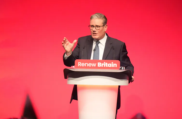 Keir Starmer at a lectern with red backdrop