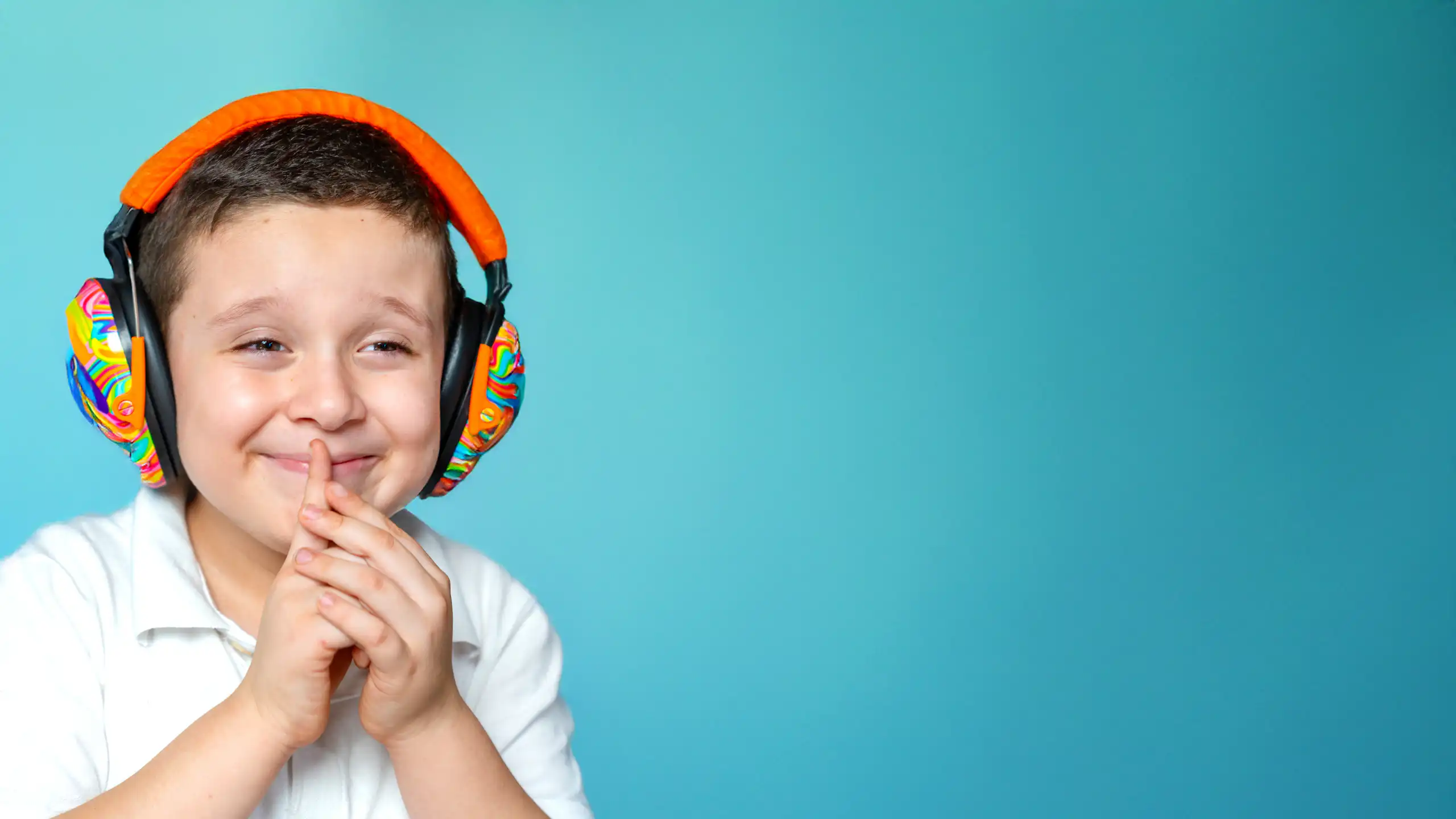 A boy sitting with colourful headphones