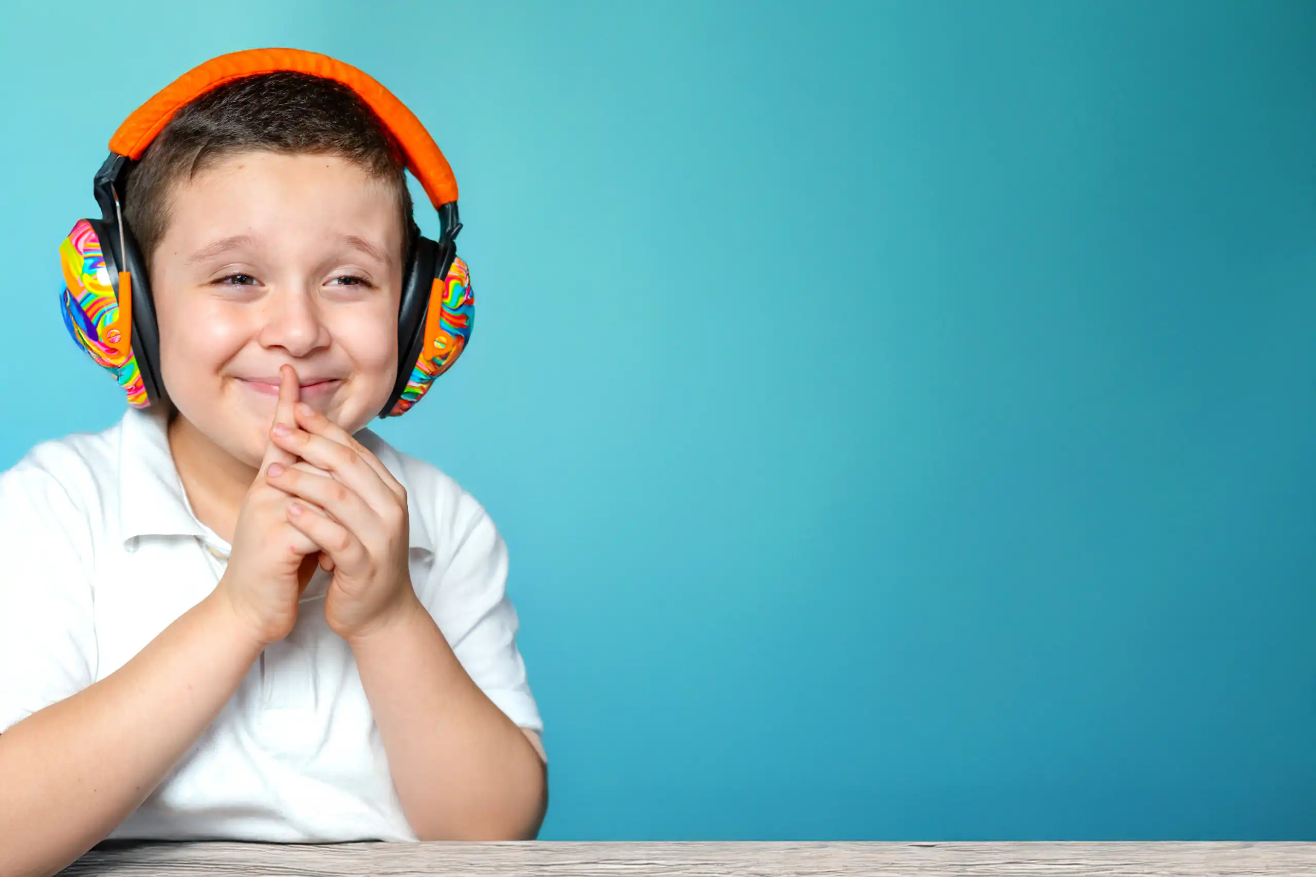 A boy sitting with colourful headphones