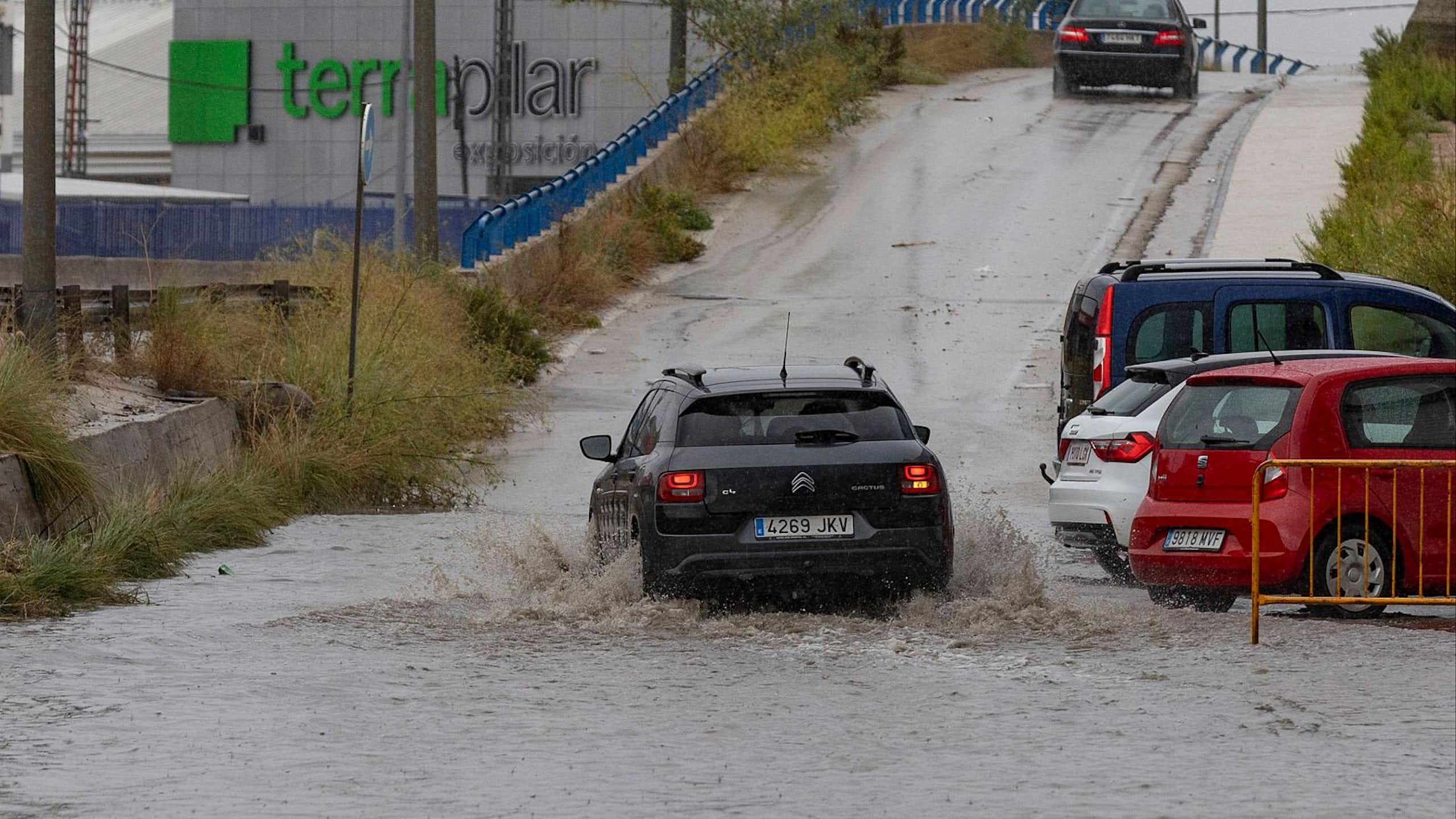 Un coche circula por una carretera inundada