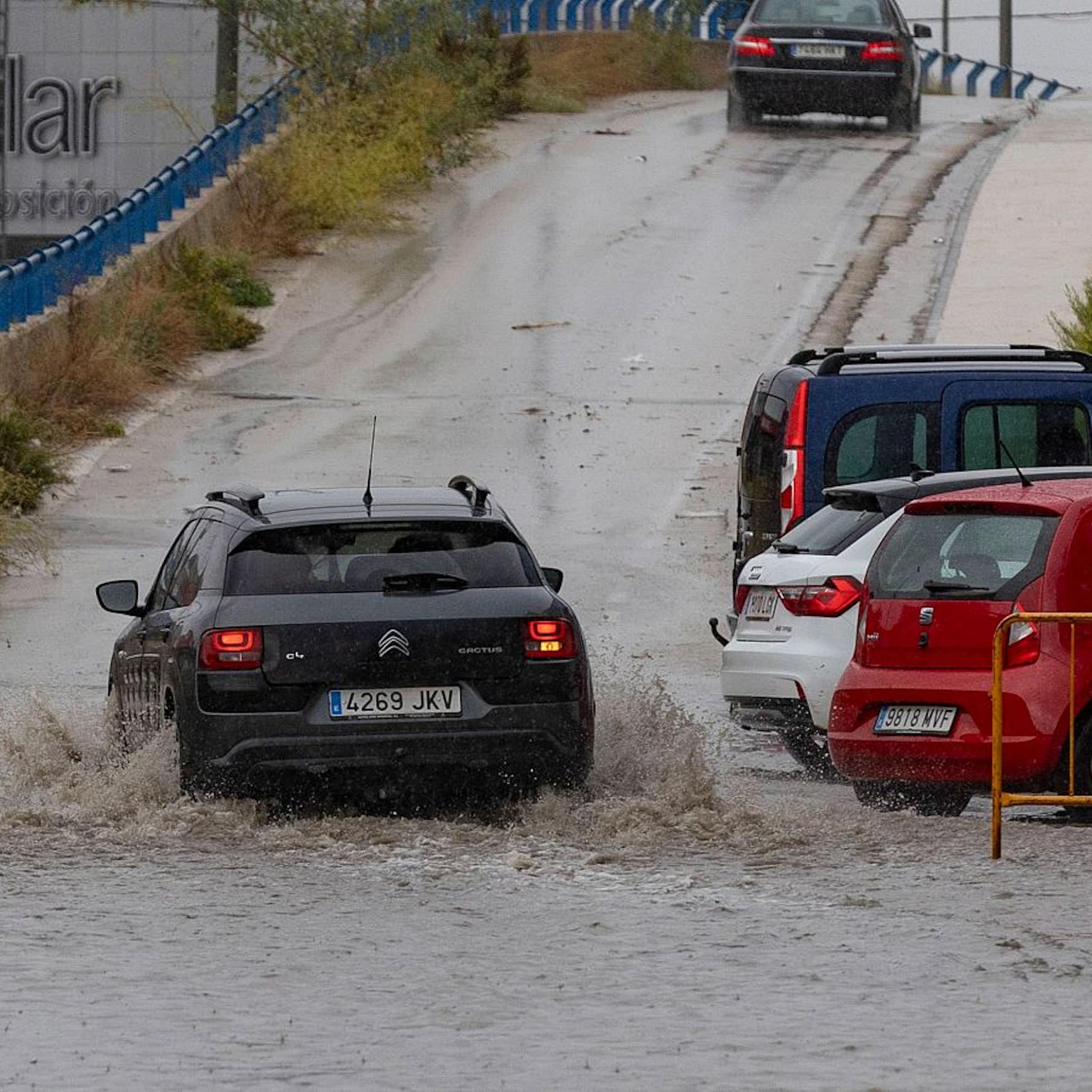 Un coche circula por una carretera inundada