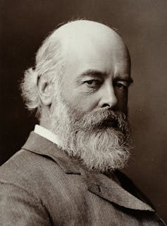 A black and white photo of a bearded man in a suit