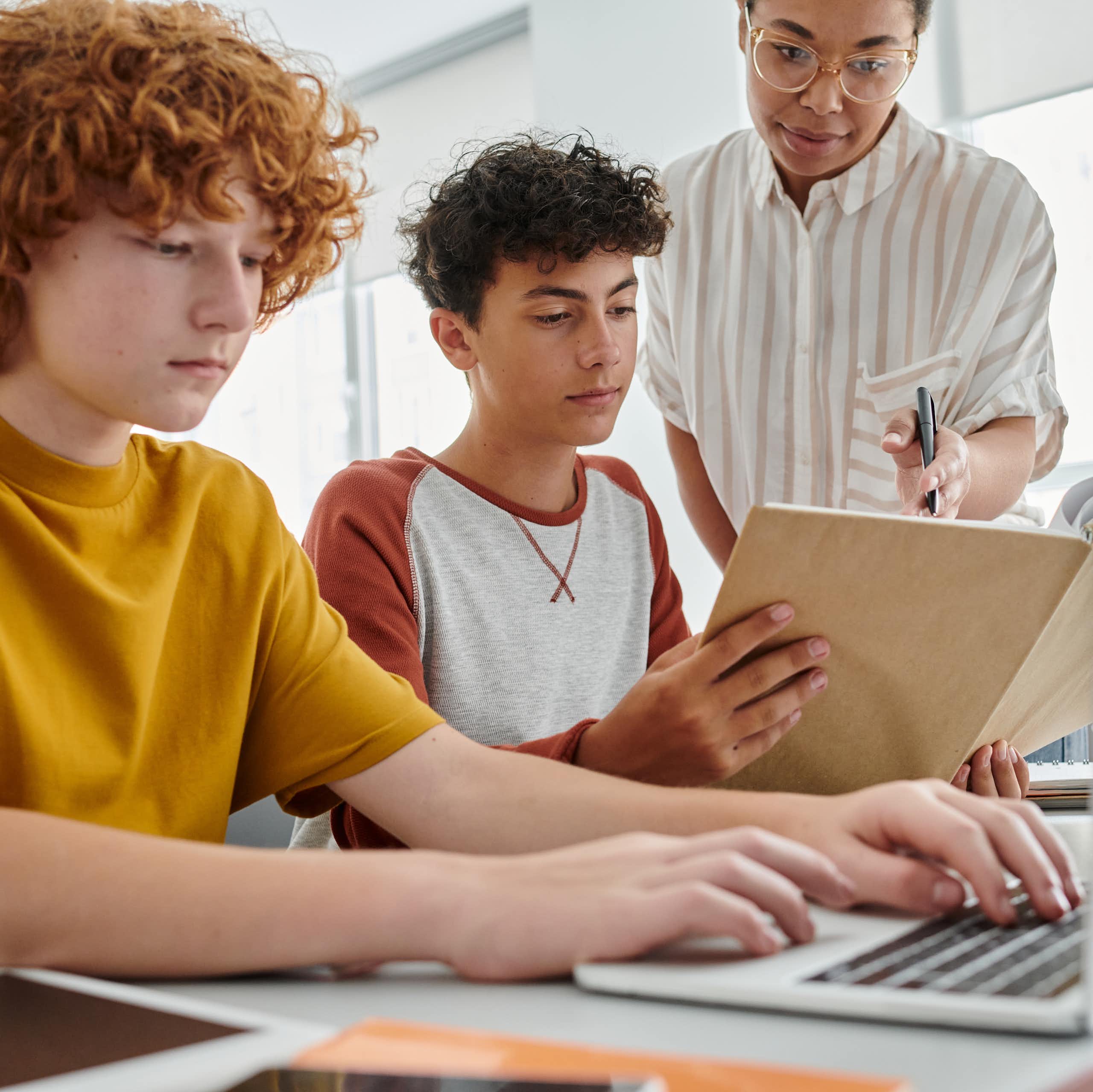 Dos alumnos con un cuaderno y un ordenador