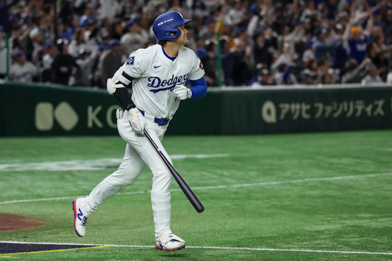 A baseball player is seen breaking into a trot with a broad smile.