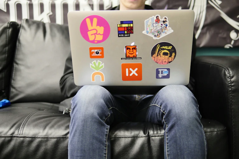 a teen boy using a laptop while sitting on a couch