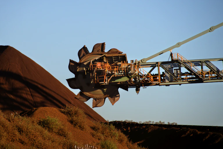 Bucket wheel of a mining reclaimer moving stockpiled iron ore