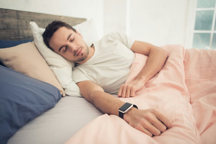 a sleeping man wears an Apple watch