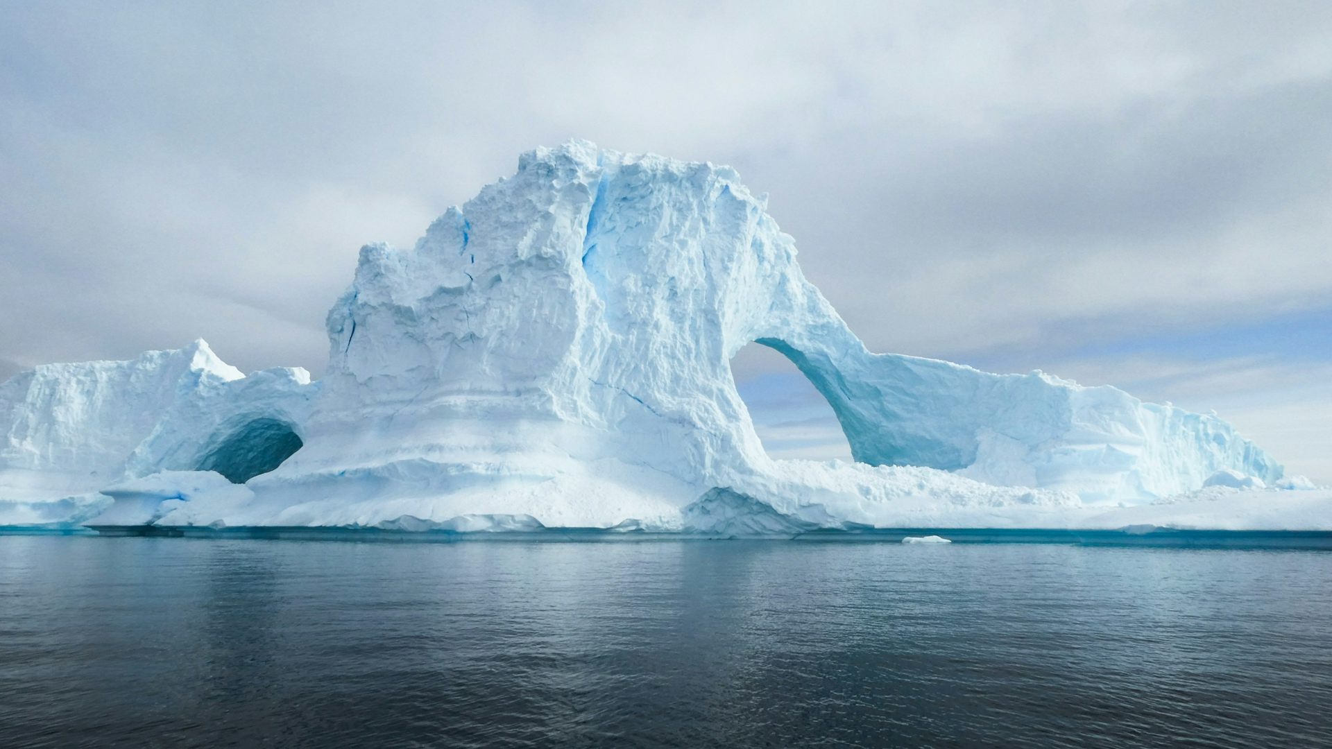 Un grand iceberg avec un trou en son sein.