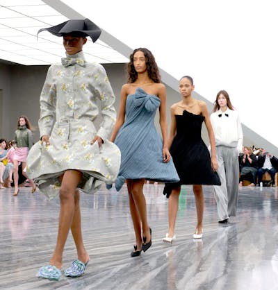 Cuatro modelos desfilan con diferentes vestidos en la pasarela.