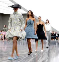 Cuatro modelos desfilan con diferentes vestidos en la pasarela.