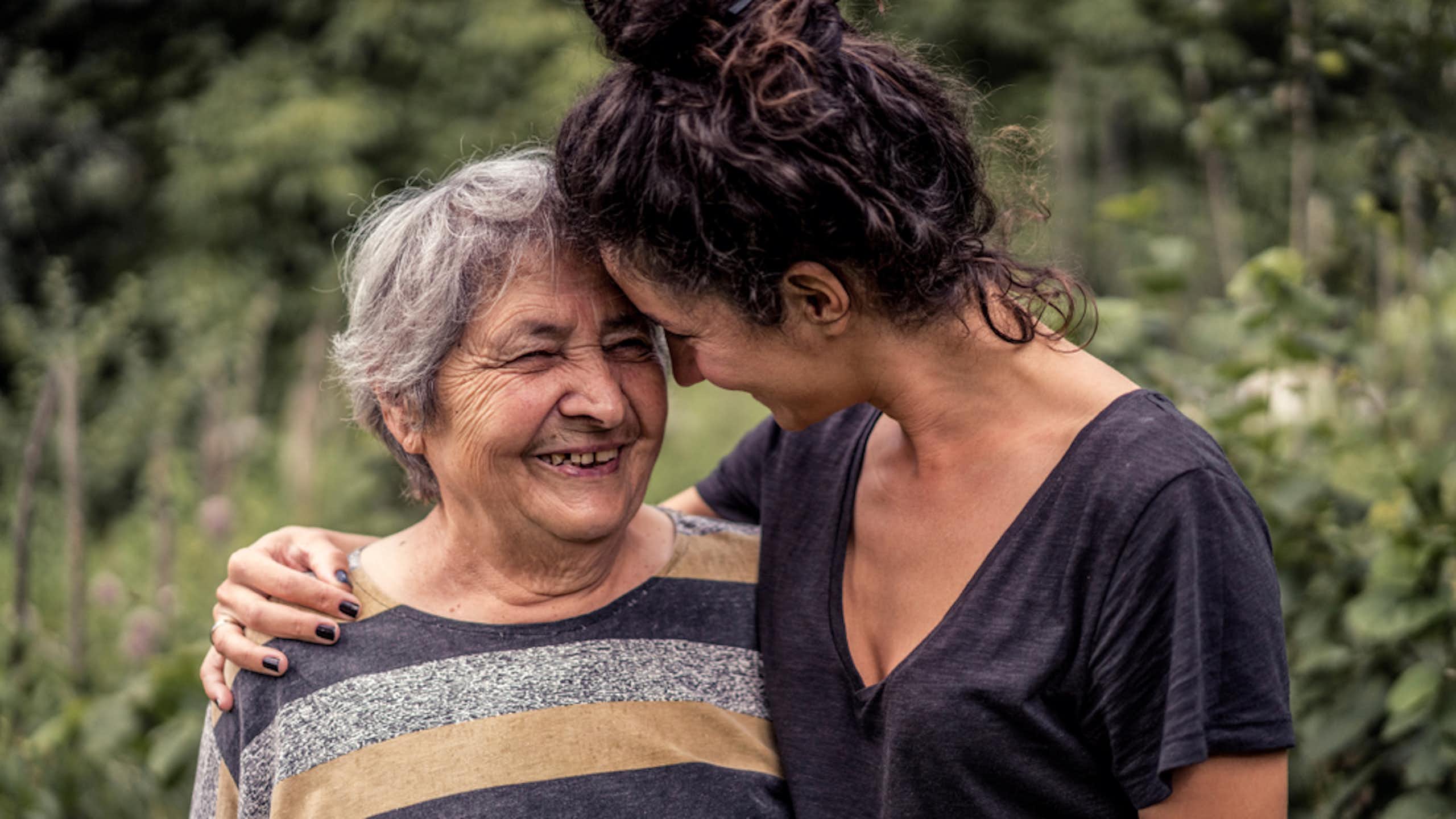 Une femme tient sa proche, une femme âgée, par l’épaule.