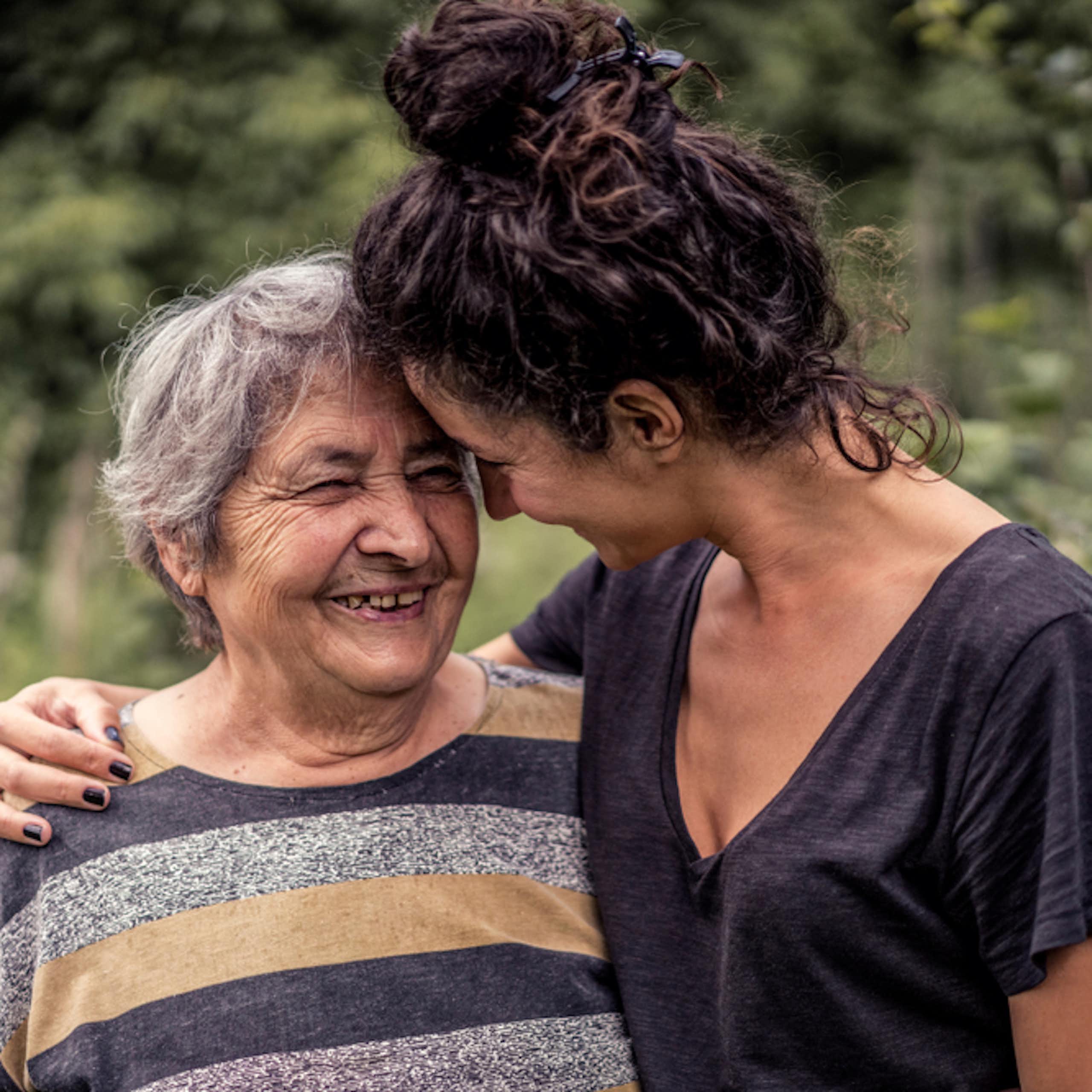 Une femme tient sa proche, une femme âgée, par l’épaule.