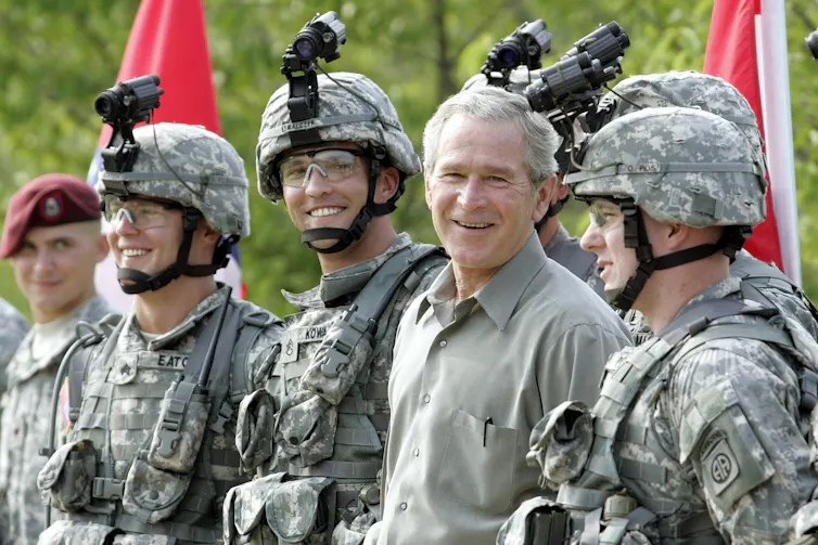 President George W. Bush appears with several soldiers.
