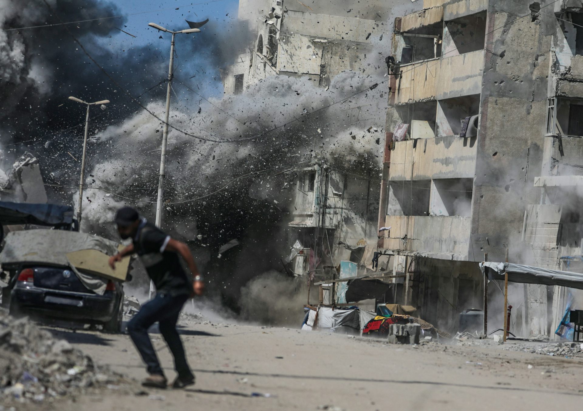 A Palestinian man takes cover following an Israeli air strike during a military operation in Gaza City in September 2025.