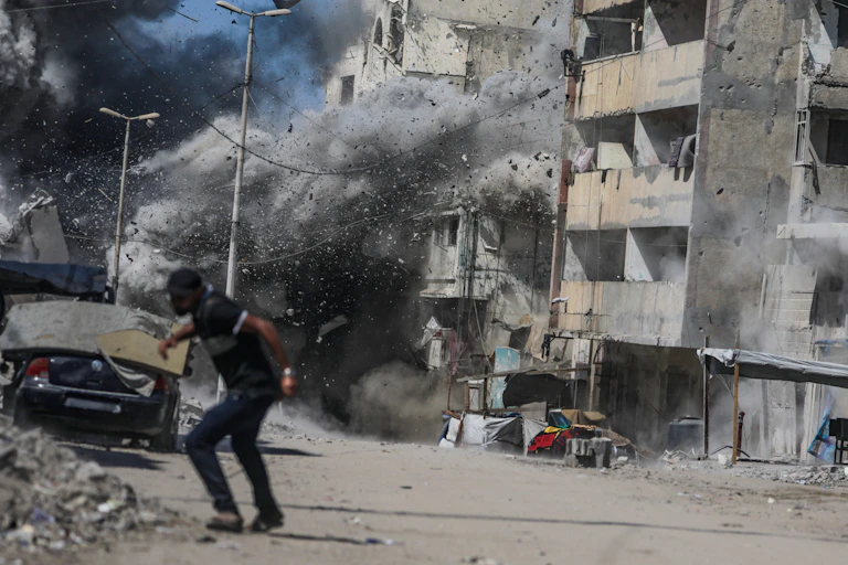 A Palestinian man takes cover following an Israeli air strike during a military operation in Gaza City in September 2025.