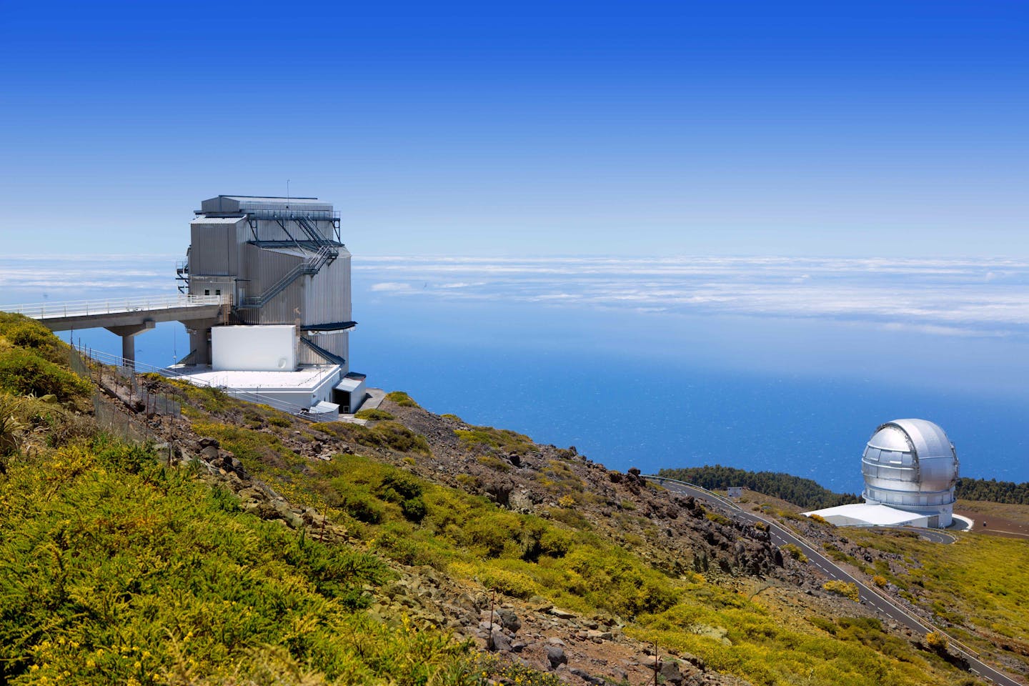 View of two hi-tech telescopes with the sea beyond.