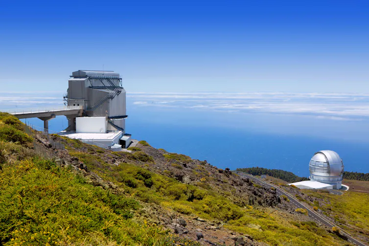 View of two hi-tech telescopes with the sea beyond.