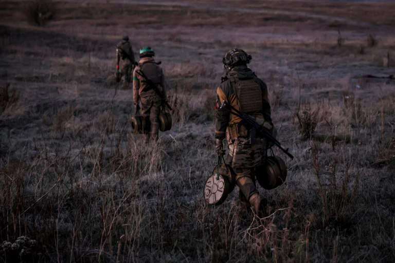 Ukrainian servicemen carrying anti-tank landmines walking near the front in Octobere 2024.