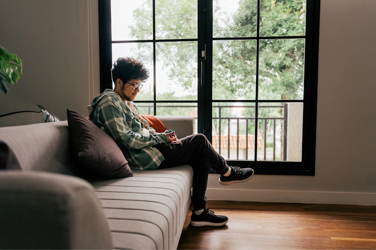 Man sits on his sofa with a fidget object